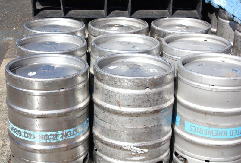 Stainless steel beer kegs lined up outside a brewery